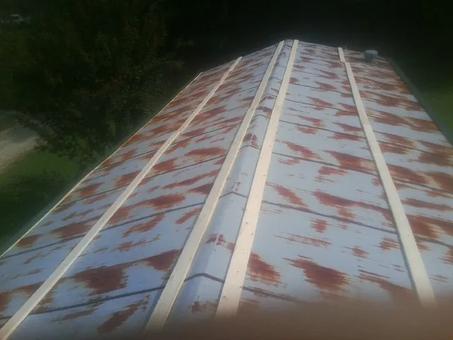 Rusted metal roof panels with new wood purlins before replacement — Storm Damage Roof Repair in Michigan Center by Roofing Brothers